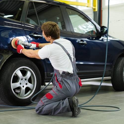 Technician repairing a damaged car dent in Dubai