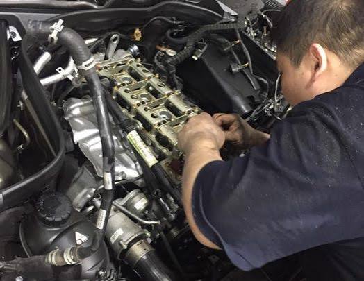 Mercedes Benz engine specialist inspecting and repairing a car engine.